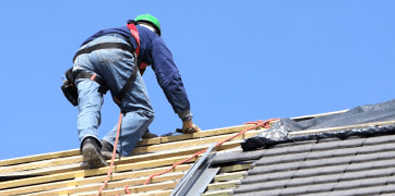 Roofer installing shingles on a residential roof